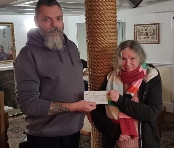 Ian Richardson hands over £900 to New Quay Memorial Hall Secretary, Moira Attrill