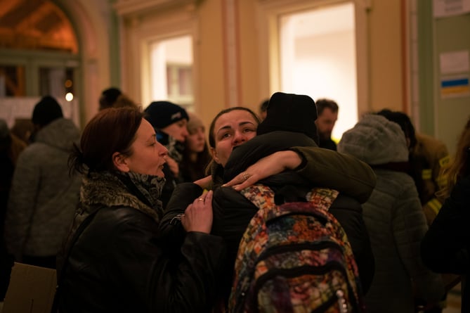 Women embrace as refugees wait for transport at PrzemyÅl train station after crossing the border from Ukraine into Poland. 28 February 2022. 
