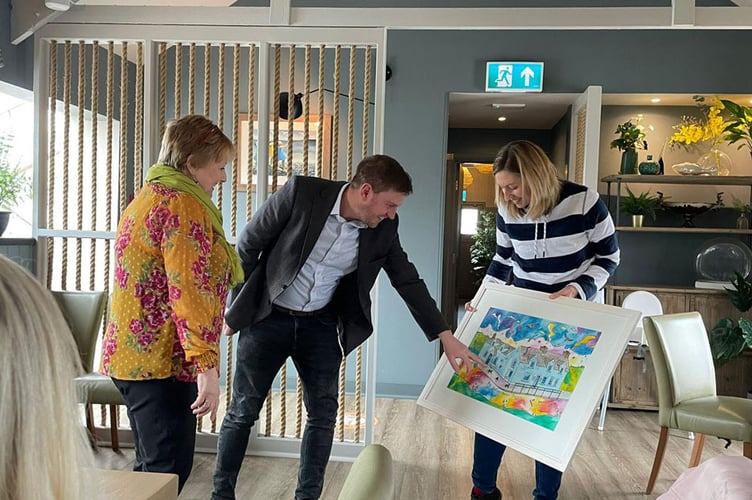 oyce Jenkins and Dr Eleri Marks presenting the painting to Dr Owain Dimmick