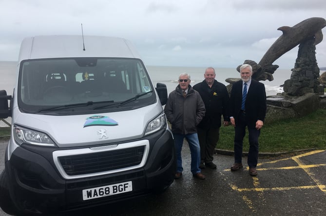 Aberporth community council chair Aled Thomas and vice chair Robin Young with Tom Cowcher of Dolen Teifi and a minibus similar to the one due to be placed in Aberporth.