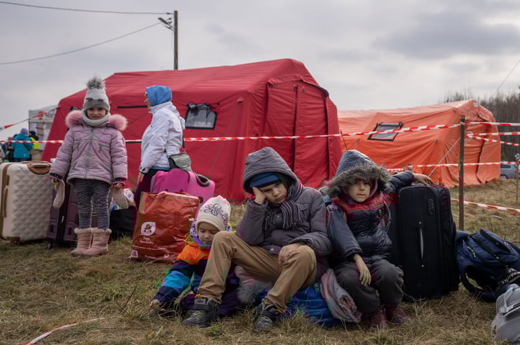 Ukrainians children sit after crossing the border from Ukraine to Budomierz, Poland. 03 March 2022. 
