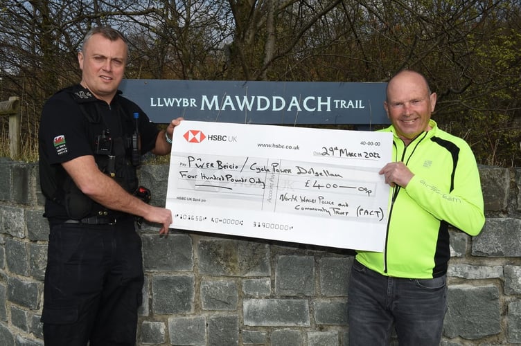 Sergeant Simon Barlow of North Wales Police hands over a £400 cheque on behalf of  the force and Community Trust (PACT) to Cycle Power volunteer Joe Patton. The money will allow the purchase of signage and safety items for the disabled cycling club.
Pic: Erfyl Lloyd Davies