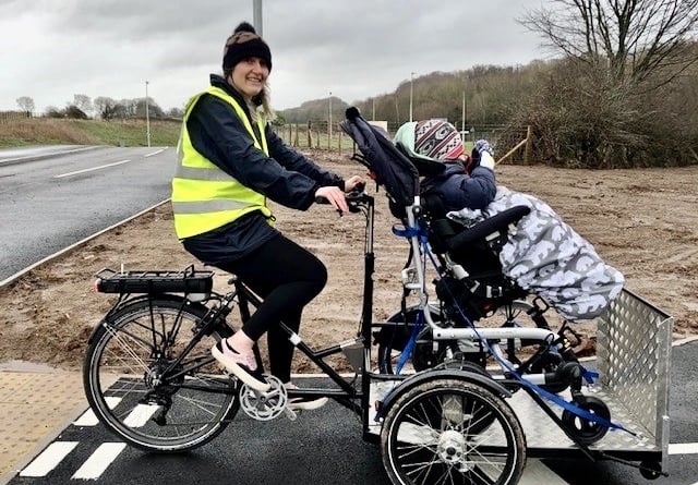 Club riders Catherine and Will are pictured here using the club’s pedal assisted electric wheelchair carrier