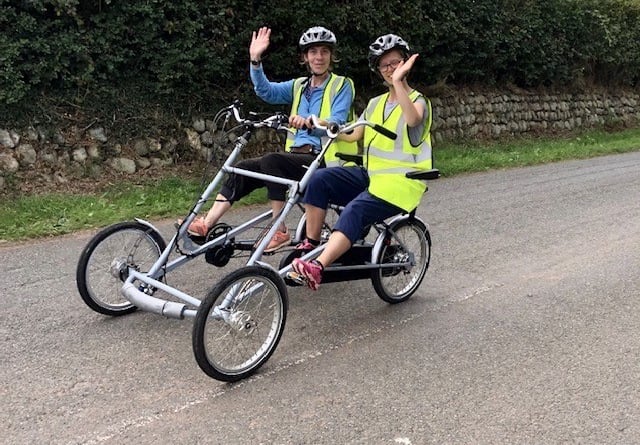 Gilly demonstrates the club’s pedal assisted electric side-by-side bicycle during a bicycle ride with daughter Cara