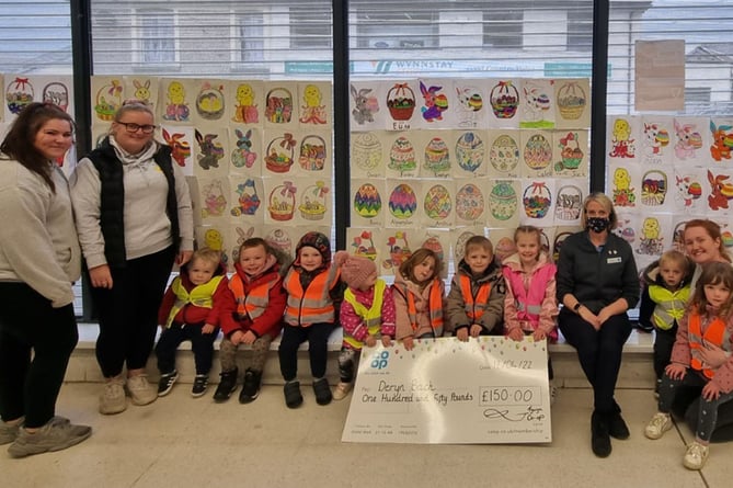 The children of the nursery collect their cheque