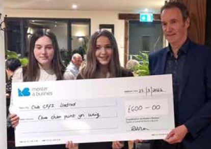 Alun Jones, Menter a Busnes chief executive presents the prize to Alaw (left) and Megan (centre)