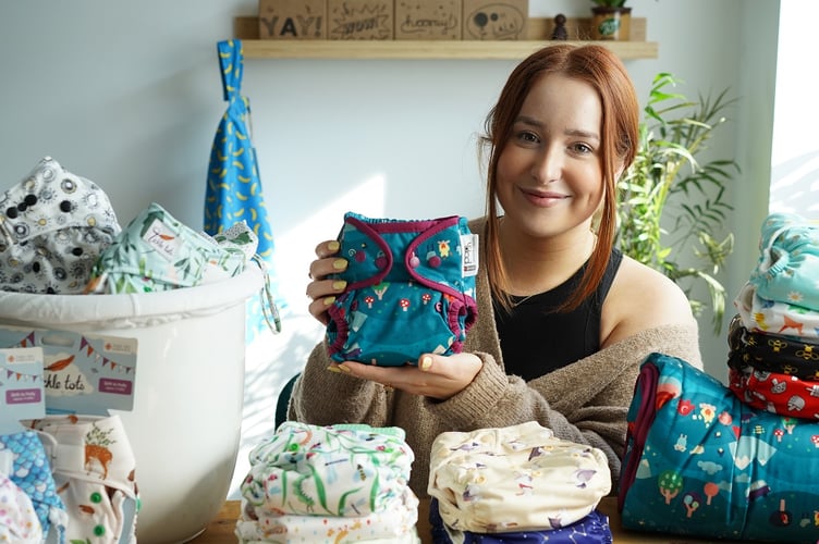 Charlotte of Porthmadog, who works at Babipur, and a selection of the reusable nappies available