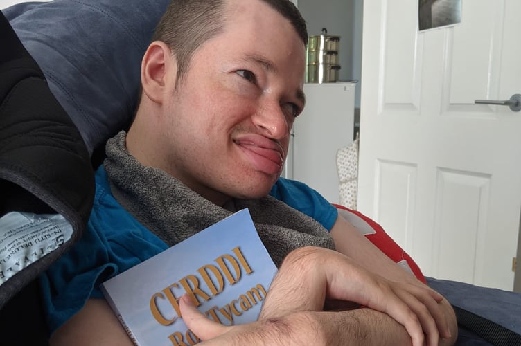 Ann and Rob’s son Llyr with a copy of Cerddi Rob Tycam