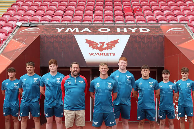 Pictured, left to right, are Keanu Evans, Ioan Lewis, Yestyn Cook, development pathway manager Kevin George, Scarlets head coach Dwayne Peel, Will Evans, Isaac Young, Steffan Jac Jones and Iori Badham
