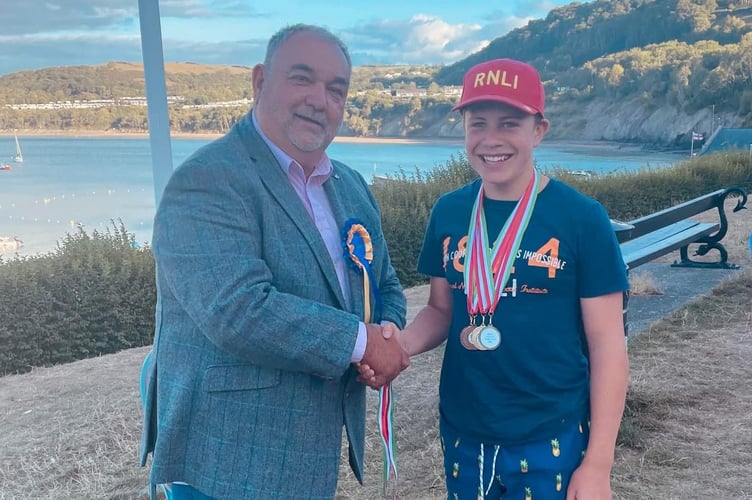 Daniel Potter presenting medals to Seffan Williams for swimming, body boarding and  paddle boarding , Cardigan Bay Regatta, 2022
