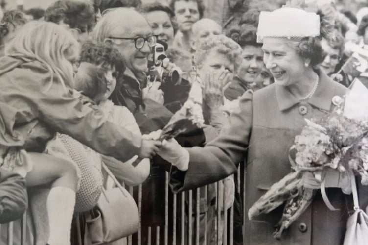 Queen Elizabeth II is handed flowers by Ruth Roberts, then five years old, during a royal visit to Machynlleth on 11 July, 1986