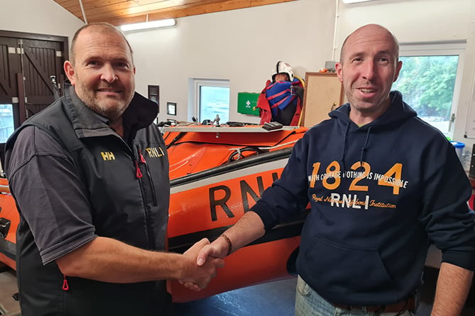 RNLI assessor Hugh Davies congratulates New Quay RNLI’s Ben Davies on passing out as helm