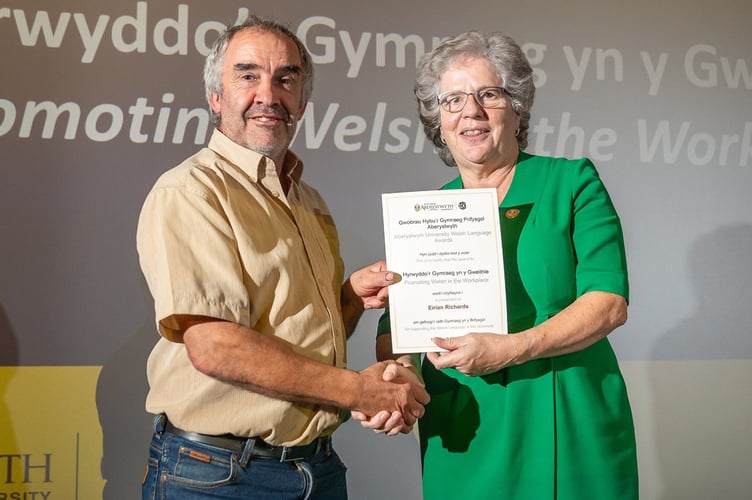Eirian Richards, Technegydd Maes yng Nghanolfan Ymchwil yr Ucheldir Pwllpeiran, yn derbyn y wobr am Hyrwyddo’r Gymraeg yn y Gweithle