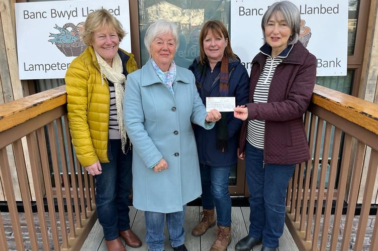 Councillors Ann Bowen Morgan and Eryl Evans handing over a cheque to Sandra Jones and Beryl Williams from Llanbedr Pont Steffan food bank.
