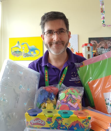 Health Play Specialist Paul Harries with some of the arts and crafts materials Hywel Dda Charities