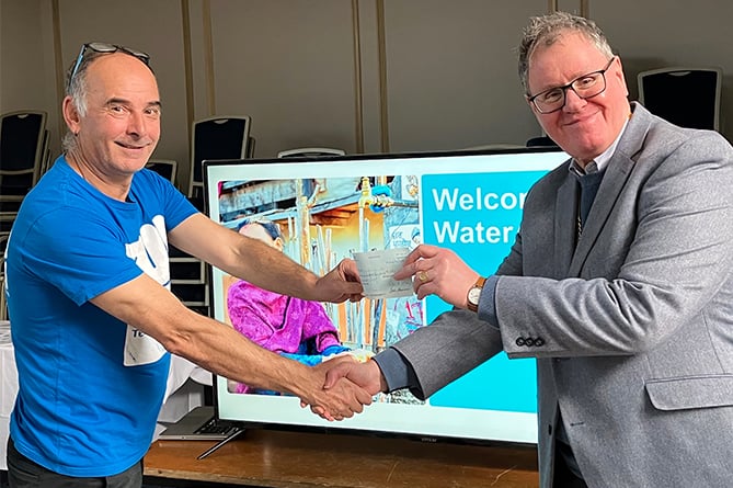 Aberystwyth Rotary Club president Hywel Davies presenting a cheque to Andy Pickett from Water Aid