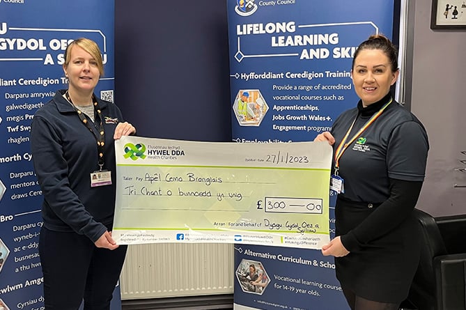 Karen Bulman, team manager for vocational and learning skills, presenting cheque to Bridget Harpwood, Hywel Dda Health Charities fundraising officer