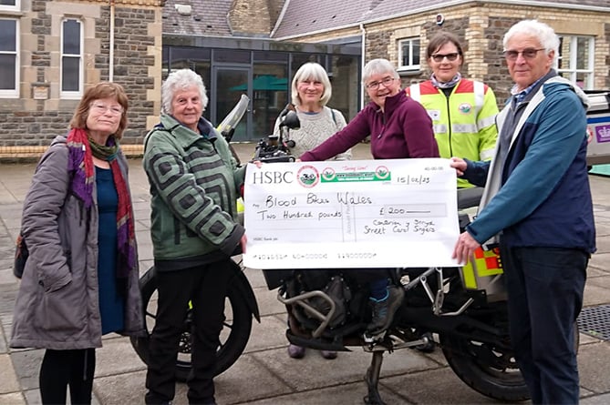 Cantorion y Stryd singers presented a cheque for £200 to representatives from the Aberystwyth branch of Blood Bikes Wales