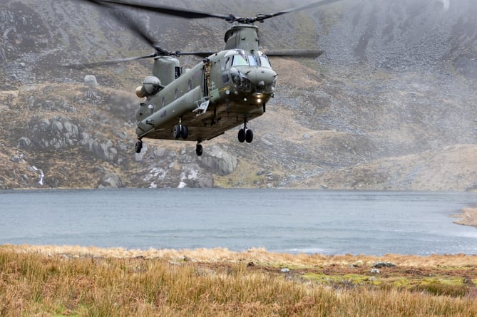 SEE SWNS STORY SWNAchinook --- Incredible scenes show an RAF Chinook on a training sortie in Wales. The heavy-lift helicopter is scene hovering against the dramatic backdrop of Snowdonia. It came as the military carried out the nine-day Exercise Kukri Dawn this month. Three Chinooks from 28 Squadron, based at RAF Benson in Oxfordshire, were operating out of RAF Valley for the duration of the exercise to train in the unique environment offered by the Snowdonia National Park. RAF Valley is a Royal Air Force station on the island of Anglesey, Wales. An RAF spokesperson explains: "An RAF spokesperson explains: "Our visual communicators will generally fly in with the helicopters, being dropped off at pre-determined spots as the aircraft conduct their training allowing captures as you see."