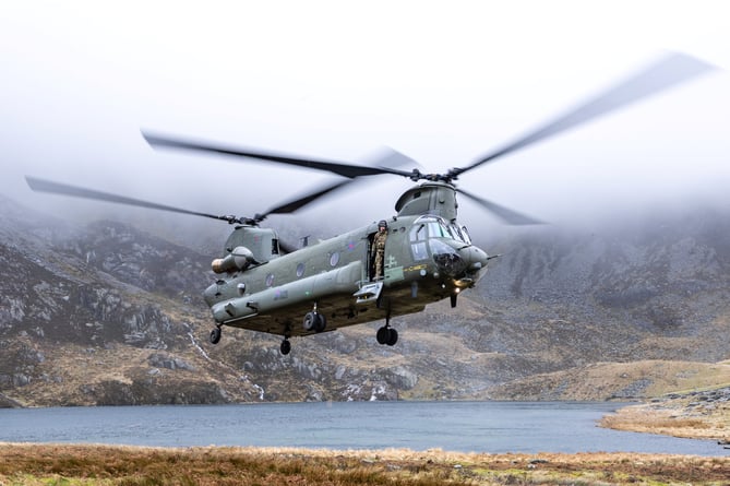 SEE SWNS STORY SWNAchinook --- Incredible scenes show an RAF Chinook on a training sortie in Wales. The heavy-lift helicopter is scene hovering against the dramatic backdrop of Snowdonia. It came as the military carried out the nine-day Exercise Kukri Dawn this month. Three Chinooks from 28 Squadron, based at RAF Benson in Oxfordshire, were operating out of RAF Valley for the duration of the exercise to train in the unique environment offered by the Snowdonia National Park. RAF Valley is a Royal Air Force station on the island of Anglesey, Wales. An RAF spokesperson explains: "An RAF spokesperson explains: "Our visual communicators will generally fly in with the helicopters, being dropped off at pre-determined spots as the aircraft conduct their training allowing captures as you see."