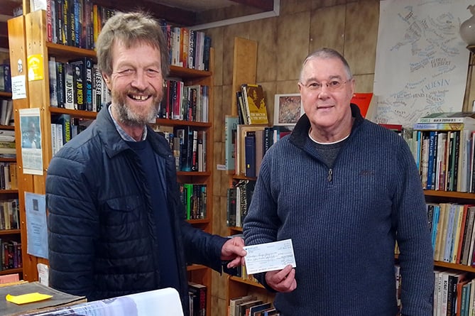 Cardigan Community Bookshop chair Guy Stoate presents a cheque to Tom Kearney, chair of the Ceredigion Badger Group