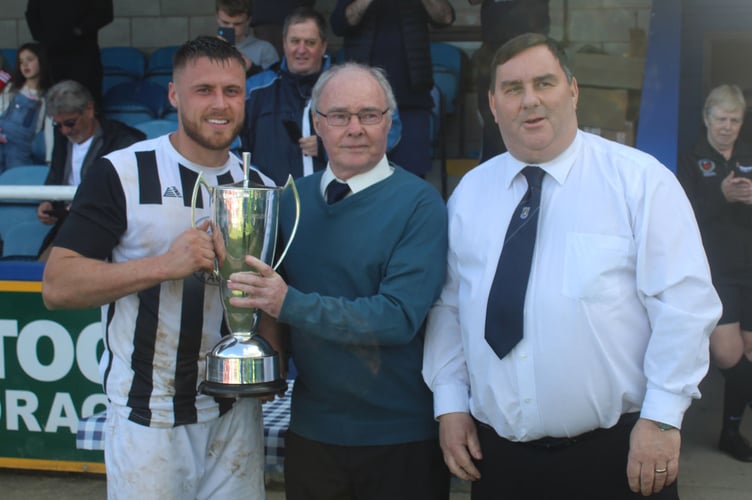 Barmouth captain Llion Owen receives the Emrys Morgan Cup from Bryn Smith 070423