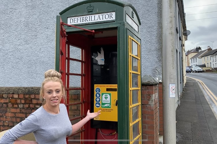 Amber Holland with a defibrillator hundreds of metres from the school where she saved her football coach's life