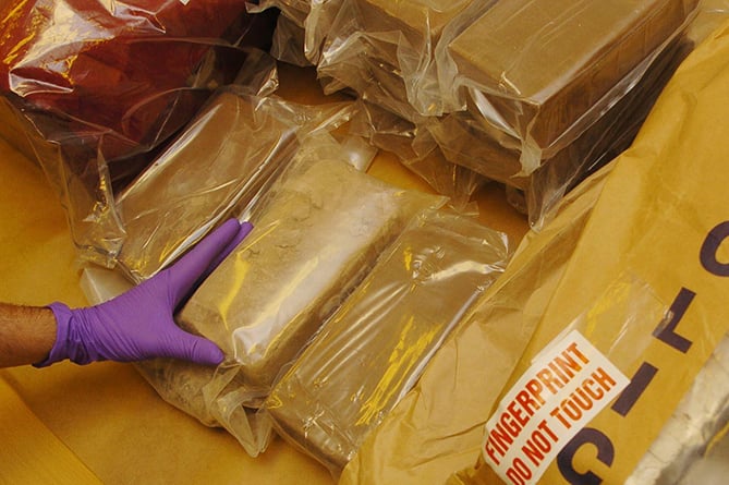 A member of staff at the Forensic Science Service in London examines part of a 33 kg haul of heroin seized by the Metropolitan Police. The heroin is being examined to aid police officers in their investigation surrounding the haul.