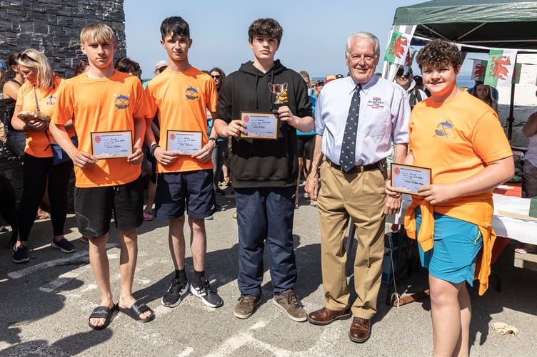 Sion Cwilt U 16s category winners and overall winner of Novice/Junior race being presented with their certificate and trophy by Roger Couch, Operations Manager at New Quay RNLI Station 2023