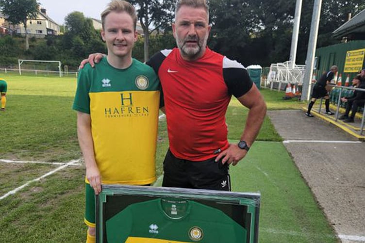 Llani captain Ed Clarke presents the shirt to Gari Lewis