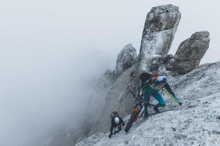 Gee Atherton in the Dolomites, a mountain range in northeastern Italy, August 2023. Photo releases September 15, 2023. See SWNS story SWMRbiker. (Please credit Dan Griffiths/Moonhead Media/SWNS). Jaw-dropping images show a daredevil British mountain biker taking on Italy mountains. Gee Atherton's latest challenge saw him riding tough terrain in the Dolomites, a range in northeastern Italy. The double World Champion is seen perilously close to steep drops in this behind-the-scenes look at the new installment of his Ridgeline Series. Filming took place this August, where access to Dolomites riding spots involved four-hour hikes, roped climbs, ladders and abseils. The team was burdened with camera equipment, drones, food supplies and Gee's bike, broken down to frame, bars and wheels to share the load.