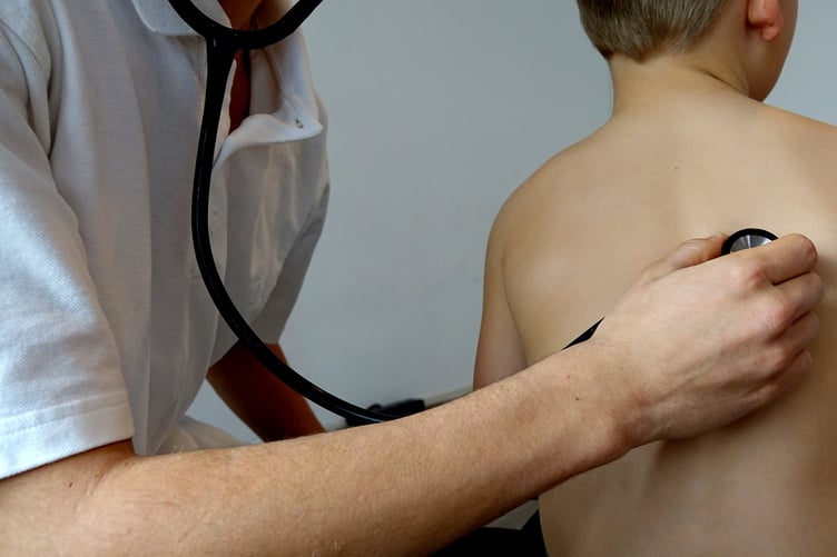 Doctor with stethoscope examining young boy