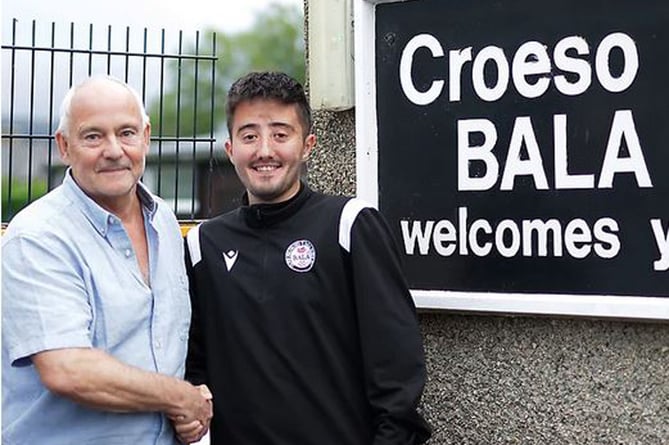Nigel Aykroyd, chief executive of Bala Town Football Club, congratulates Dan McNeil on his new role with the club’s academy