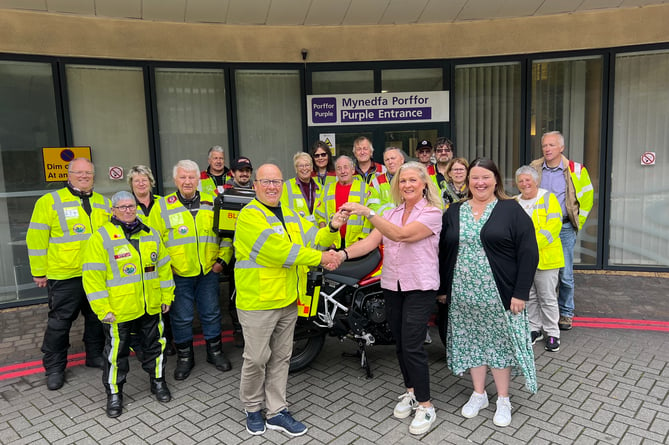 Elinor Powell, chair of Bronglais Hospital League of Friends, and Rhian Davies, trustee, present the keys of new motorcycle, ‘Gwen’, to Blood Bikes Wales volunteers