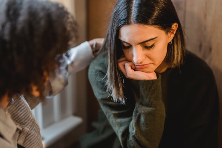 Young woman being supported by counsellor or friend