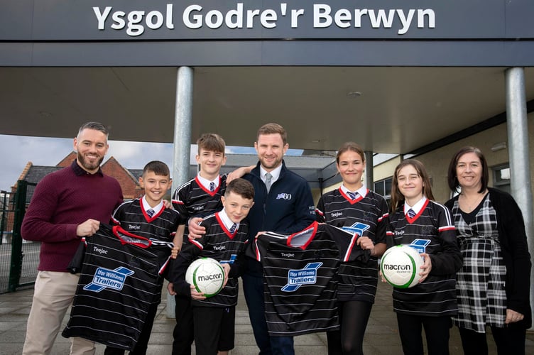ifor Williams Trailers sponsor Ysgol Godre's Berwyn football team;   (Centre) Jak Tyrer of IWT with (L/R)  PE teacher Owain Williams,Finley Benny, Harri Tyrer, Kayden Harding, Cari Rowlands , Betsan Ap Gwynfor and Maria Jones head of Phase 2.                            Picture Mandy Jones