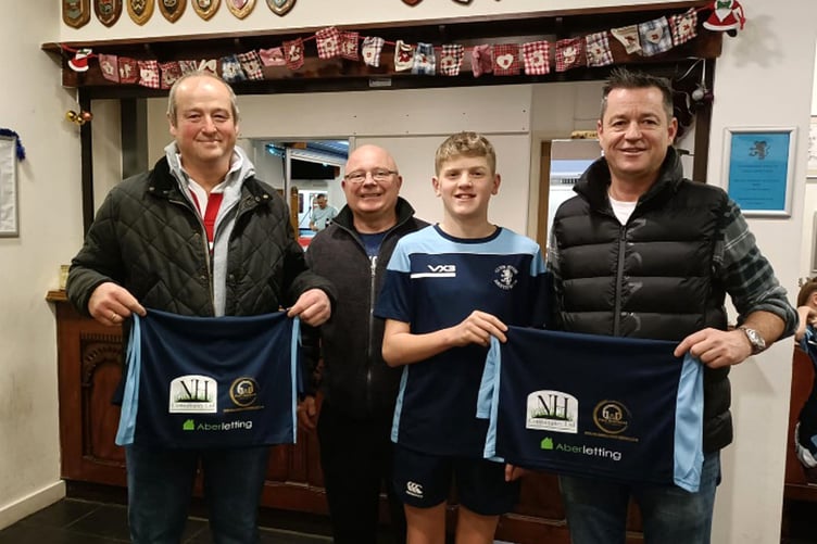 Team captain Twm Williams receiving the kit from the sponsors
