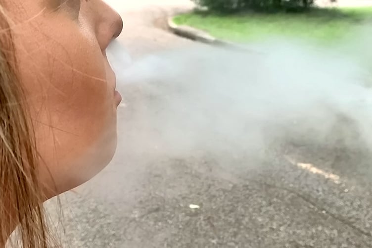 FILE PICTURE - Woman blowing e-cigarette smoke - vaping. Release date January 29 2024. See SWNS story SWSCvape. An impending UK ban on disposable vapes will affect one in seven young adults, according to new research. The proposal, recently announced by Prime Minister Rishi Sunak, will affect an estimated one in 20 adults across the nation. A study, funded by Cancer Research UK, found a recent surge in young adults using disposable vapes - some of whom had never smoked tobacco before. But the researchers behind the study warn that a ban on disposable vapes, which Mr Sunak says will aim to stamp out vaping in children, could make would-be vapers turn to more harmful alternatives such as tobacco smoking.