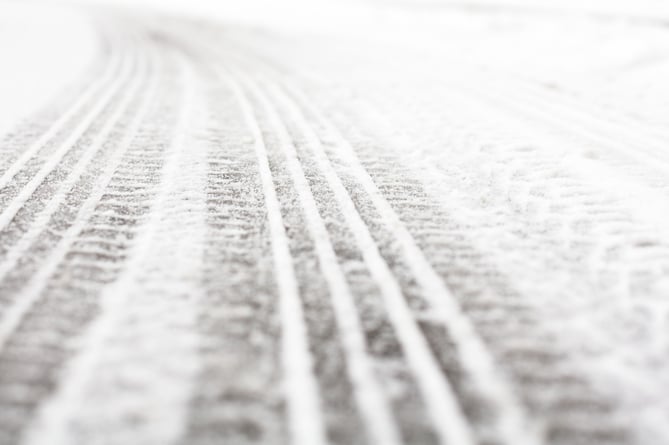 Wheel tracks on the winter road covered with snow