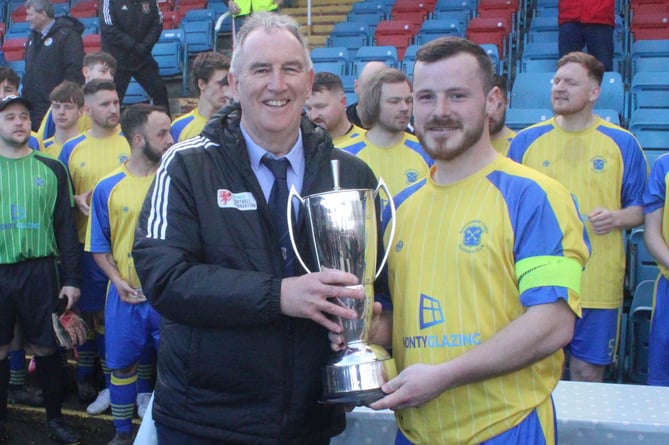 FAW Council member Wyn Lewis presents the cup to Montgomery captain Aled Davies