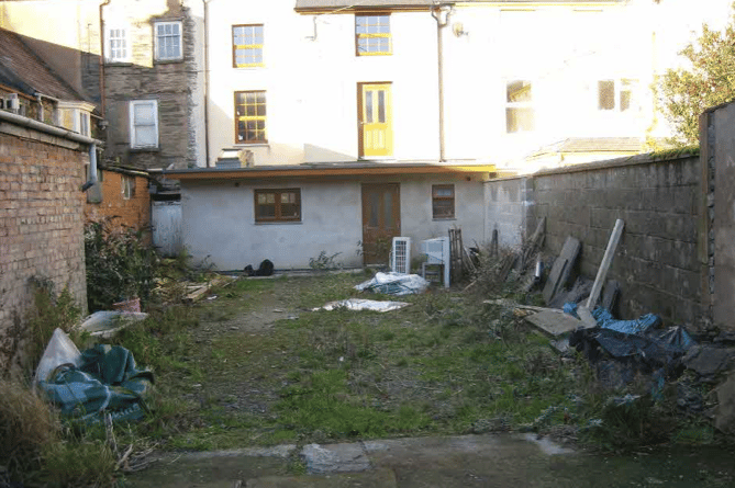 The 'rubbish-strewn yard' would be turned into two small gardens for the cottages. This photo faces north to the back of the Heol Maengwyn properties. The new cottages would be constructed to replace the bakehouse (left)