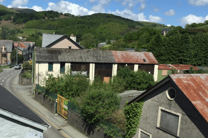 The former Travis Perkins building yard on Heol Y Doll contains two buildings and gated yard