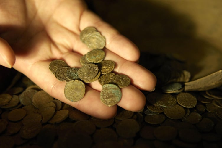 Part of a Roman coin hoard found in Snodland in north Kent is looked at closely by a British Museum worker; the coin hoard, discovered by a digger driver, is made up of over 3,600 coins and is part of the British Museum's annual report of treasure finds at the British Museum in London.
