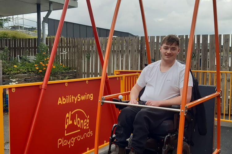 Lewis Walker demonstrating the wheelchair adapted swing