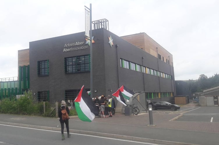 A group congregated outside Aberystwyth University AberInnovation building to protest a workshop taking place inside