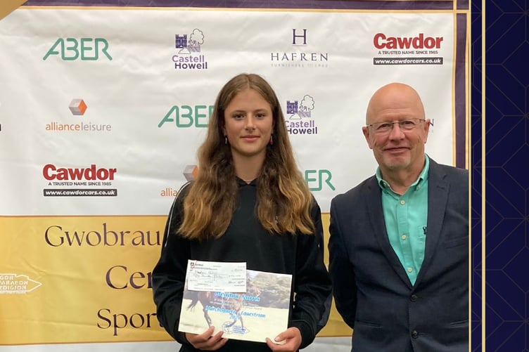 Meadow Norris receiving an award for Talented Juniors from Cllr Alun Williams.