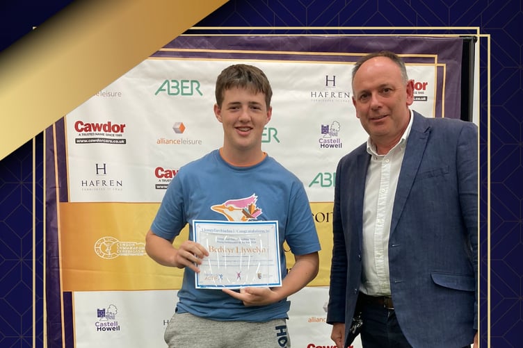 Bedwyr Llywelyn receiving the Young Ambassador of the Year award from Tim Morgan of Hafren Furnishers