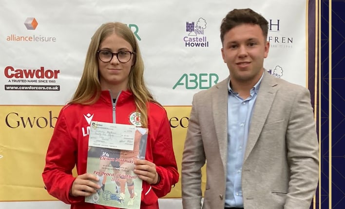 Lleucu Mathias receiving International Athletes award from Thomas Jones of Castell Howell