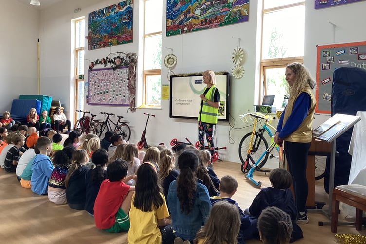 Alice Baynton from Sustrans awarding Plascrug School with the Gold Active Journeys Award in assembly.