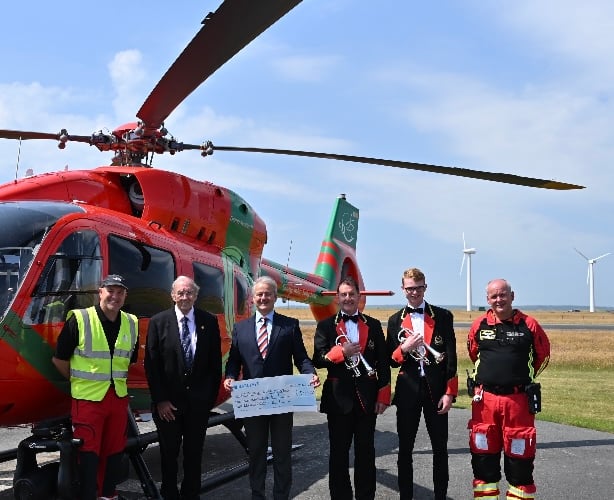 Members of The Royal Oakeley Silver Band present £2,500 to the Wales Air Ambulance charity